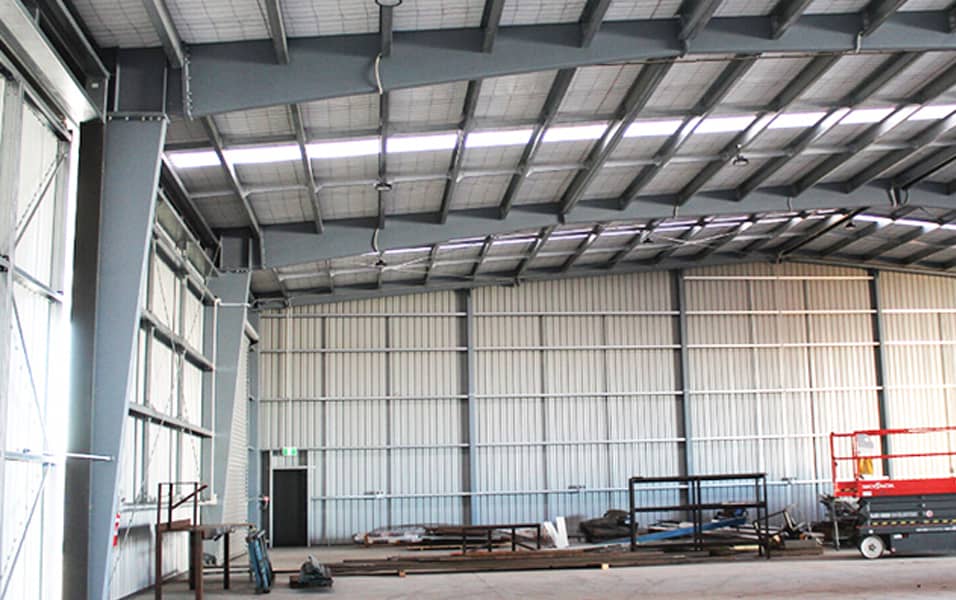 Spacious 30 x 40 metal building interior with steel beams, skylights, and equipment for industrial use.
